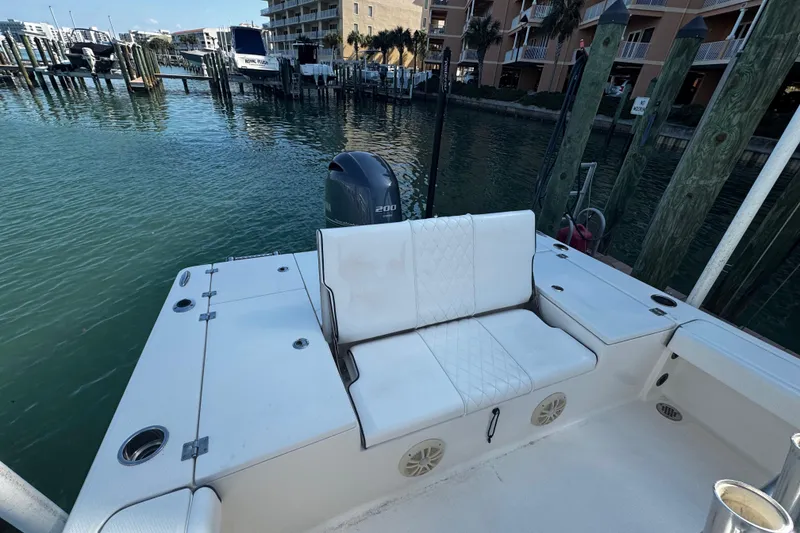 Slide: The Image of 2015 Robalo 226 Cayman boat with white seating, docked at a marina. - 32