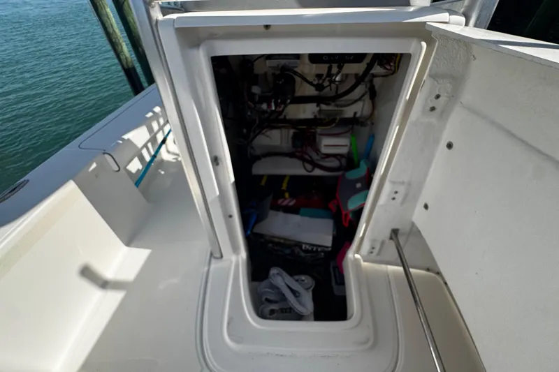 Slide: The Image of Open storage compartment on a 2015 Robalo 226 Cayman boat, showing interior equipment. - 36
