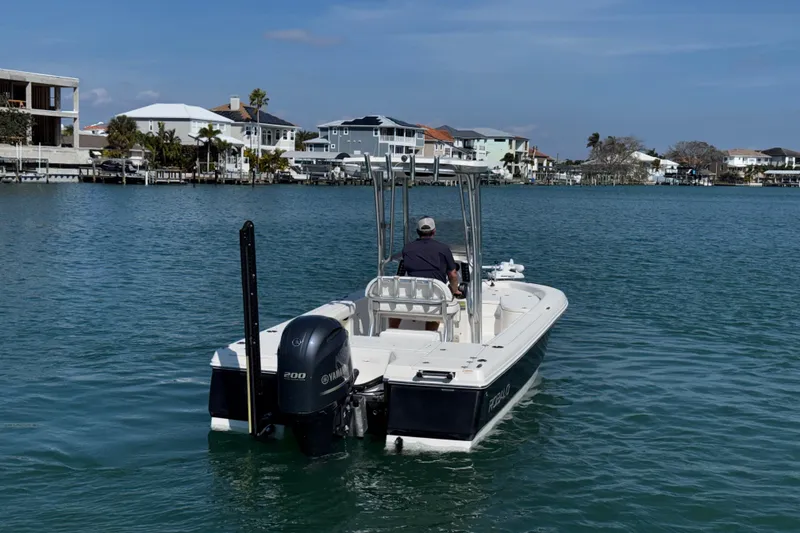 Slide: The Image of 2015 Robalo 226 Cayman boat cruising on a calm waterway near residential area. - 4