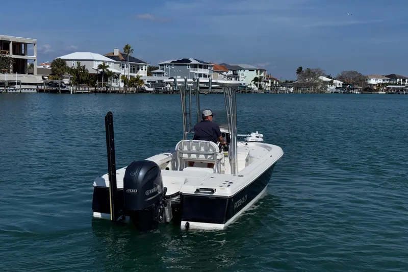 Slide: The Image of 2015 Robalo 226 Cayman boat cruising on a calm waterway near waterfront homes. - 5