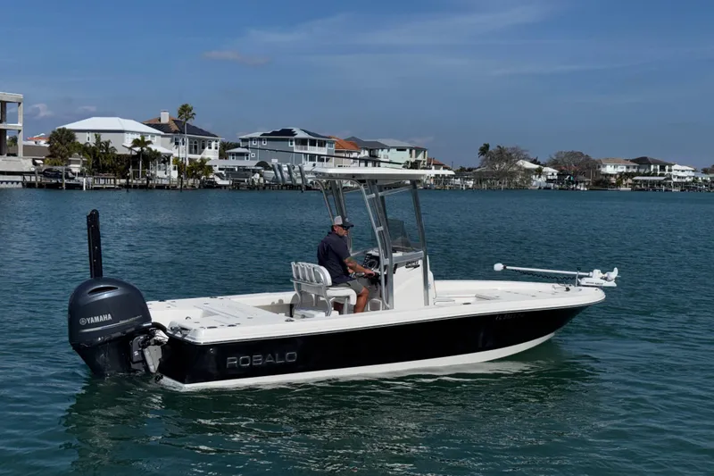 Slide: The Image of 2015 Robalo 226 Cayman boat on water with Yamaha engine, coastal houses in background. - 7