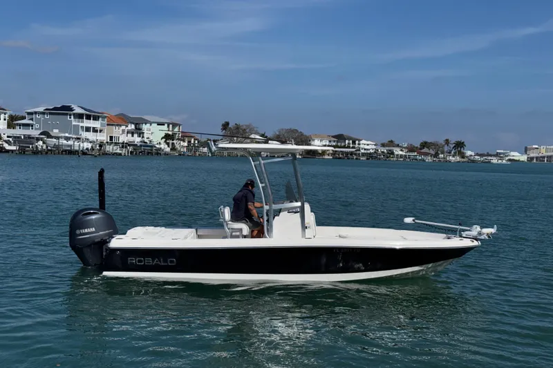 Slide: The Image of 2015 Robalo 226 Cayman boat on water, with Yamaha engine, coastal background. - 9