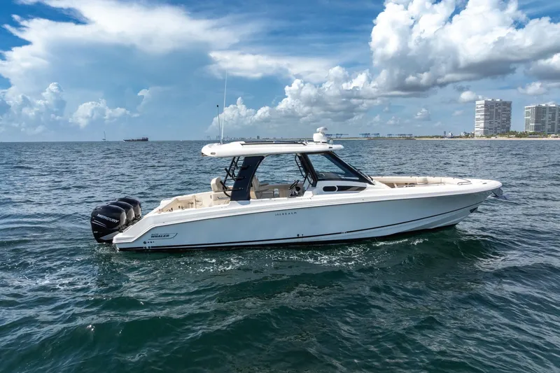 Slide: The Image of 2023 Boston Whaler 350 Realm boat cruising on open water under a cloudy sky. - 1