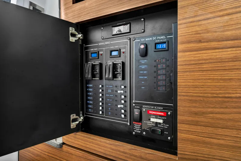 Slide: The Image of Electrical control panel inside 2023 Boston Whaler 350 Realm boat, featuring various switches and displays. - 10
