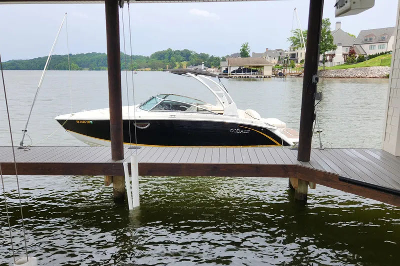 Slide: The Image of 2015 Cobalt R5 boat docked on a serene lake with waterfront homes. - 3