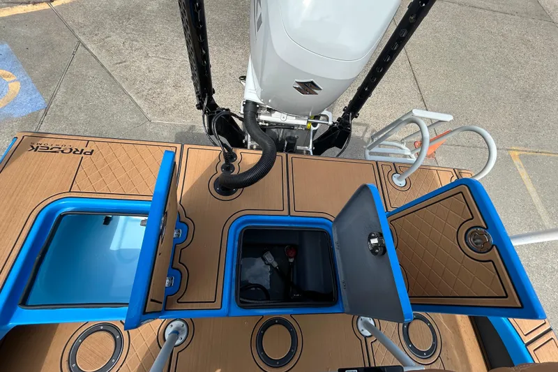 Slide: The Image of 2026 Skuta 24 Skuta Cat boat deck with open storage compartments and motor view. - 10