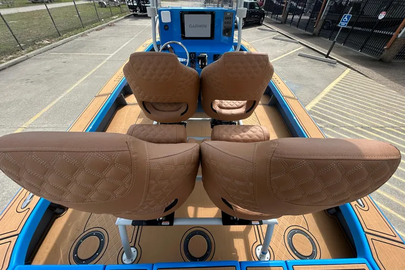 Slide: The Image of 2026 Skuta 24 Skuta Cat boat interior with brown quilted seats and Garmin navigation system. - 11