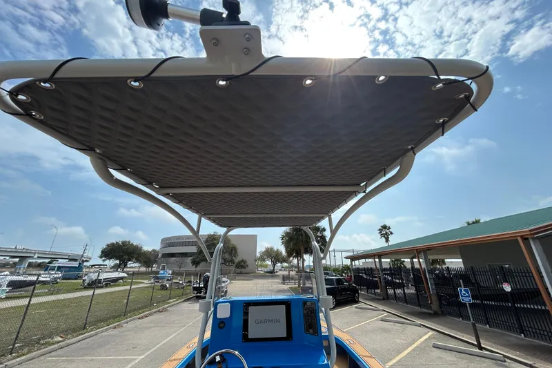 Slide: The Image of 2026 Skuta 24 Skuta Cat boat with Garmin navigation, featuring a shaded canopy under a sunny sky. - 12