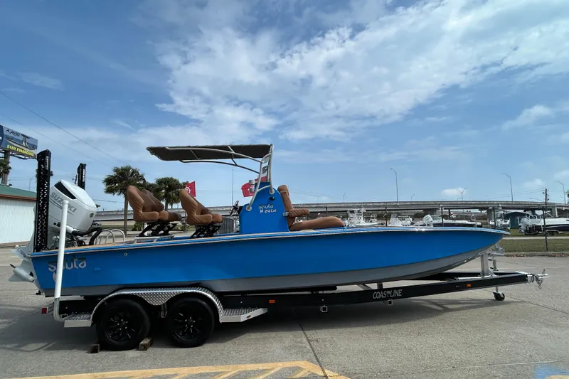 Slide: The Image of 2026 Skuta 24 Skuta Cat boat on trailer, blue hull, outdoor setting. - 3