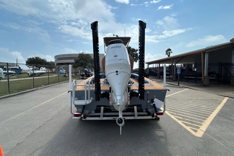 Slide: The Image of 2026 Skuta 24 Skuta Cat boat with powerful outboard motor on trailer. - 5