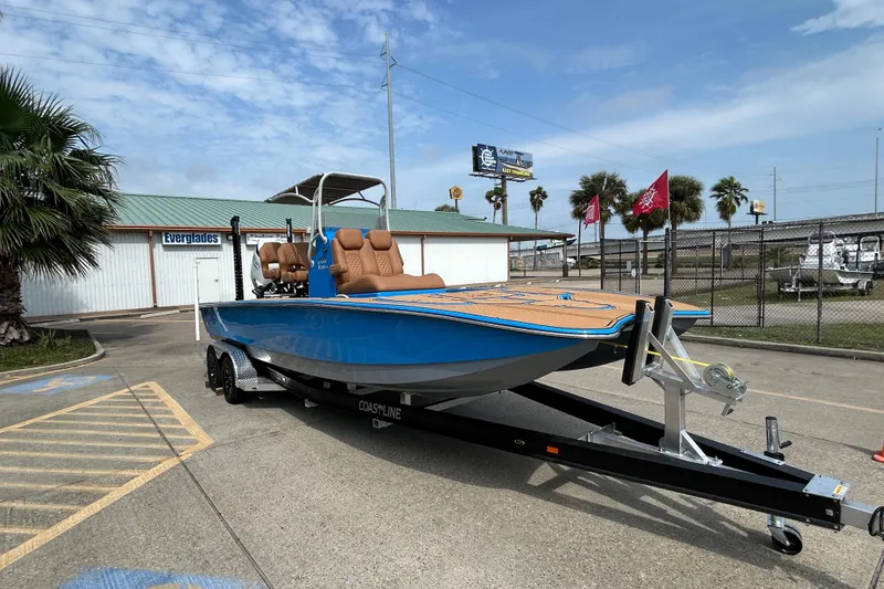 Slide: The Image of 2026 Skuta 24 Skuta Cat boat on trailer, blue hull, parked outdoors. - 8