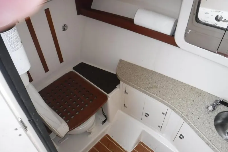 Slide: The Image of 2014 Grady-White Freedom 335 boat bathroom with toilet, sink, and storage cabinets. - 16