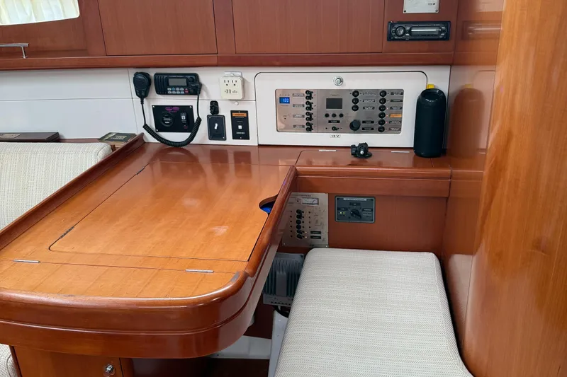 Slide: The Image of Navigation station of a 2007 Beneteau 49 yacht with control panels and seating. - 16