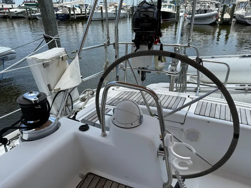 Slide: The Image of Cockpit of a 2007 Beneteau 49 sailboat with steering wheel and marina view. - 27
