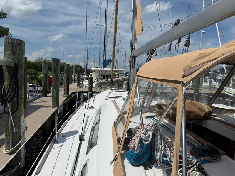 Slide: The Image of 2007 Beneteau 49 sailboat docked at marina, clear sky, ropes on deck. - 32