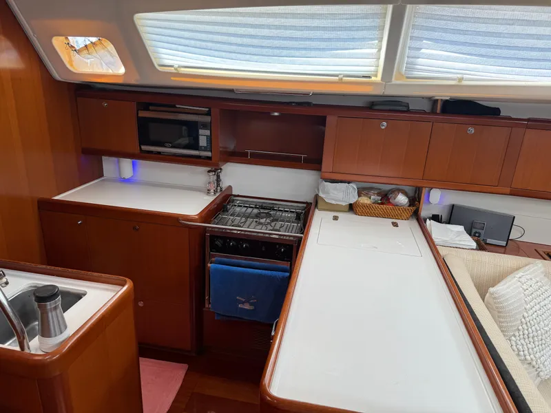 Slide: The Image of Interior of 2007 Beneteau 49 yacht kitchen with stove, microwave, and wooden cabinetry. - 4