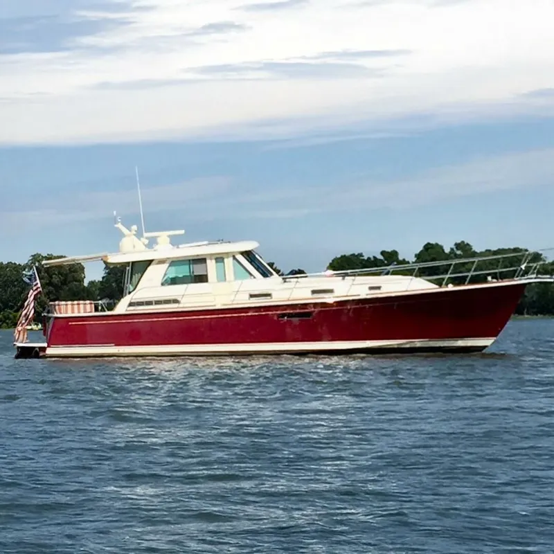 The Image of 2014 Sabre 48 Salon Express yacht on calm water, featuring a sleek red hull. - 1