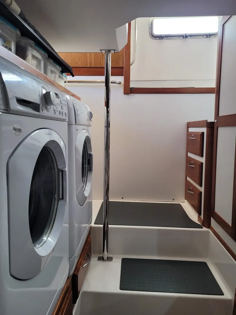 Slide: The Image of Laundry area in 2014 Sabre 48 Salon Express yacht with stairs and storage cabinets. - 15