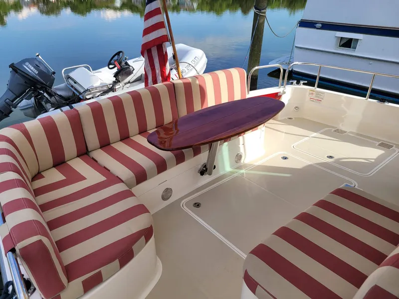 Slide: The Image of 2014 Sabre 48 Salon Express yacht with striped seating and wooden table on deck. - 3