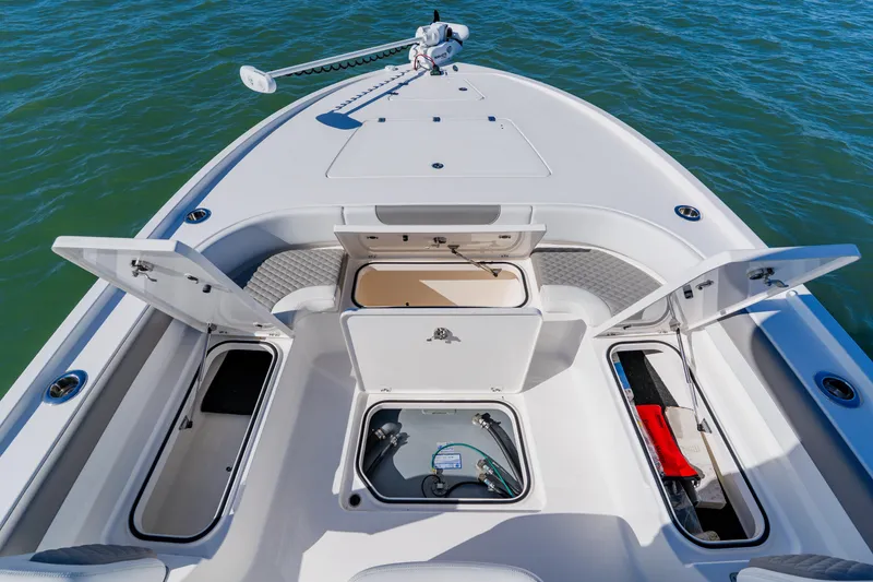 Slide: The Image of 2022 Caymas 28 HB boat deck with open storage compartments on the water. - 10