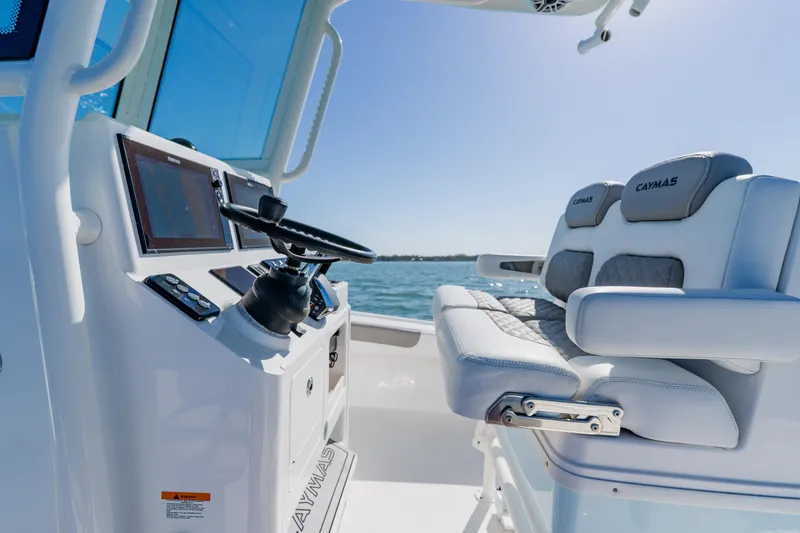 Slide: The Image of 2022 Caymas 28 HB boat interior with steering console and cushioned seating. - 21