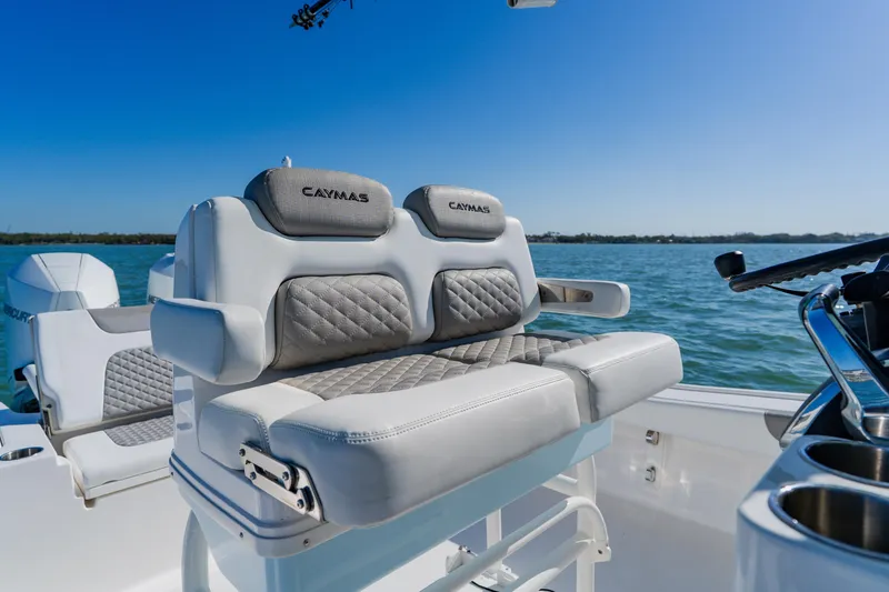 Slide: The Image of 2022 Caymas 28 HB boat with cushioned seating, on a sunny day at sea. - 22