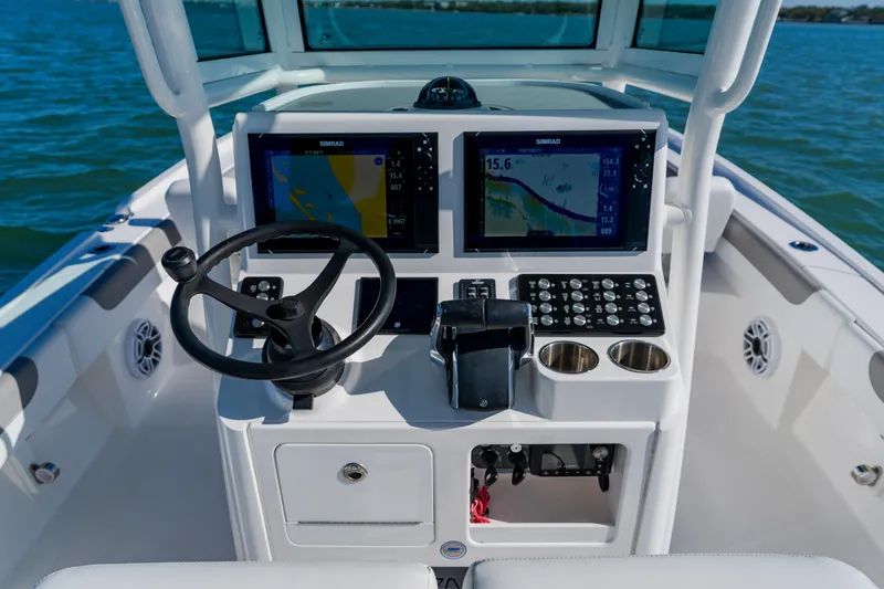 Slide: The Image of 2022 Caymas 28 HB boat dashboard with dual Simrad displays and steering wheel. - 24