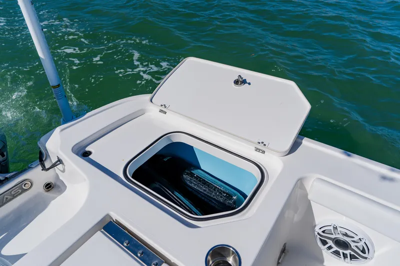 Slide: The Image of 2022 Caymas 28 HB boat with open storage compartment on deck, near water. - 37