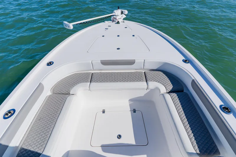 Slide: The Image of Bow view of 2022 Caymas 28 HB boat with cushioned seating and storage. - 9