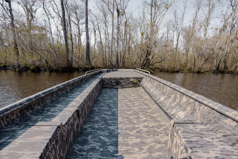 Slide: The Image of 2026 Havoc 1756 DBST boat on a calm river, surrounded by trees. - 13