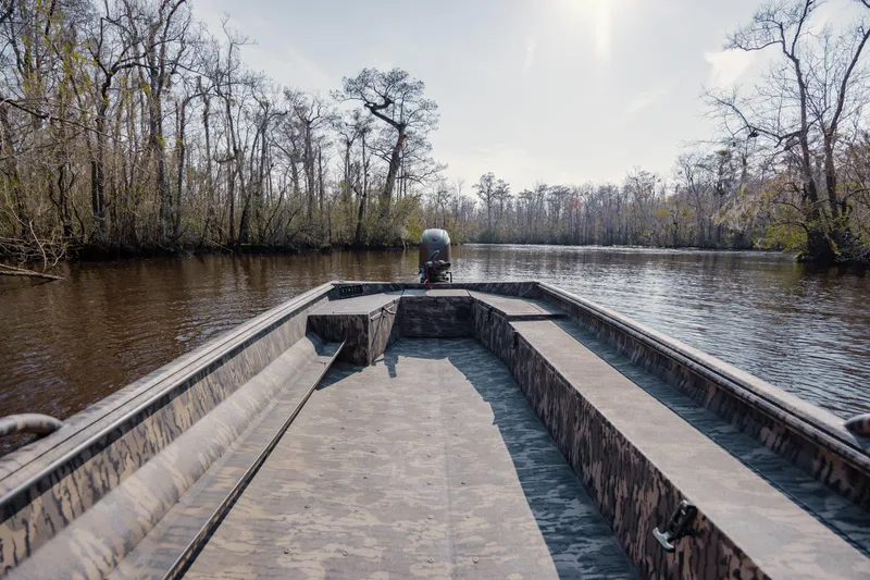 Slide: The Image of 2026 Havoc 1756 DBST boat navigating a serene river surrounded by trees. - 14