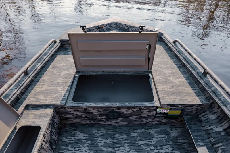 Slide: The Image of 2026 Havoc 1756 DBST boat with open storage compartment on calm water. - 18