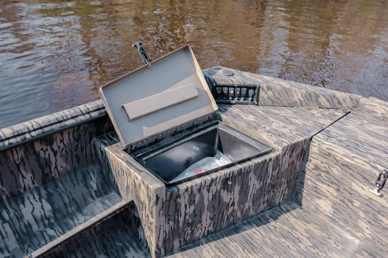 Slide: The Image of Camouflage-patterned 2026 Havoc 1756 DBST boat with open storage compartment on a river. - 20