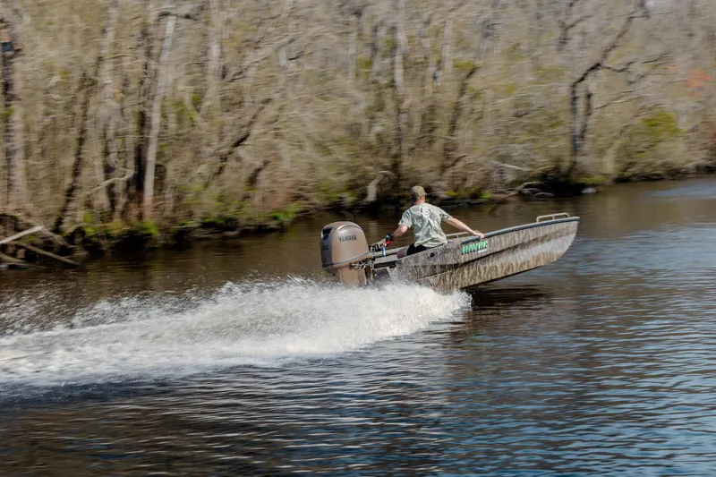 Slide: The Image of Man driving 2026 Havoc 1756 DBST boat on a river, surrounded by trees. - 3