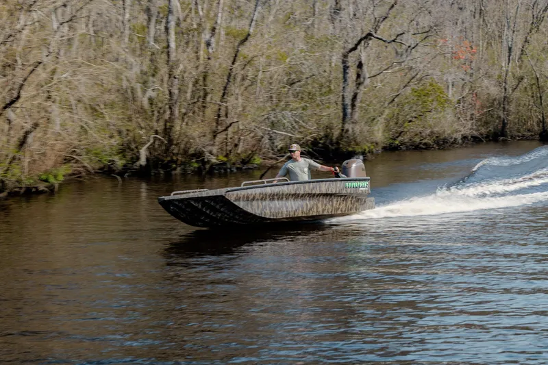 Slide: The Image of 2026 Havoc 1756 DBST boat speeding on a river with forested banks. - 4