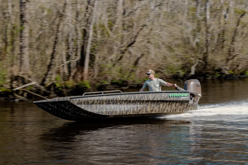 Slide: The Image of 2026 Havoc 1756 DBST boat speeding on a river with forested background. - 5