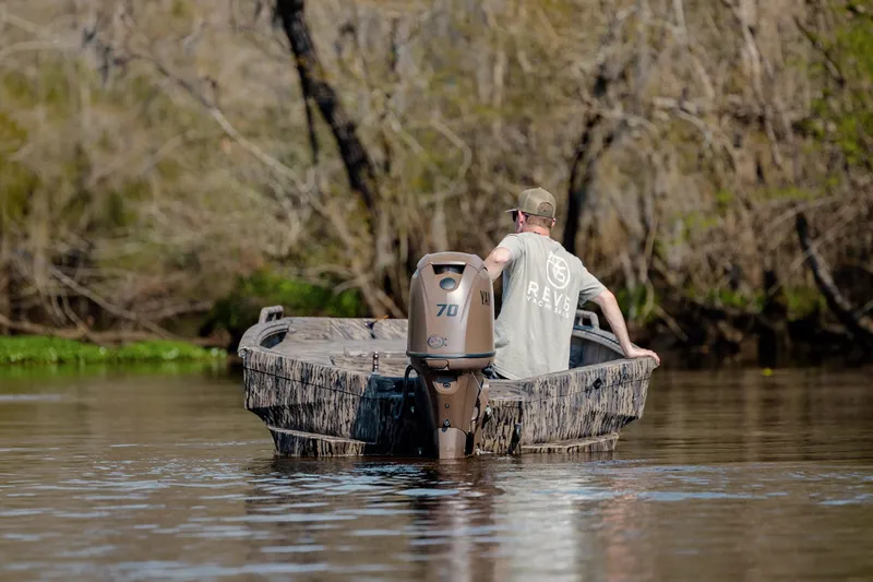 Slide: The Image of Man navigating a 2026 Havoc 1756 DBST boat through a wooded waterway. - 8