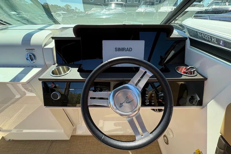 Slide: The Image of 2024 Sea Ray SDX 250 Outboard helm with steering wheel and Simrad display. - 12