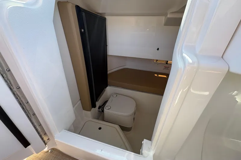 Slide: The Image of 2024 Sea Ray SDX 250 Outboard interior cabin with compact toilet. - 17