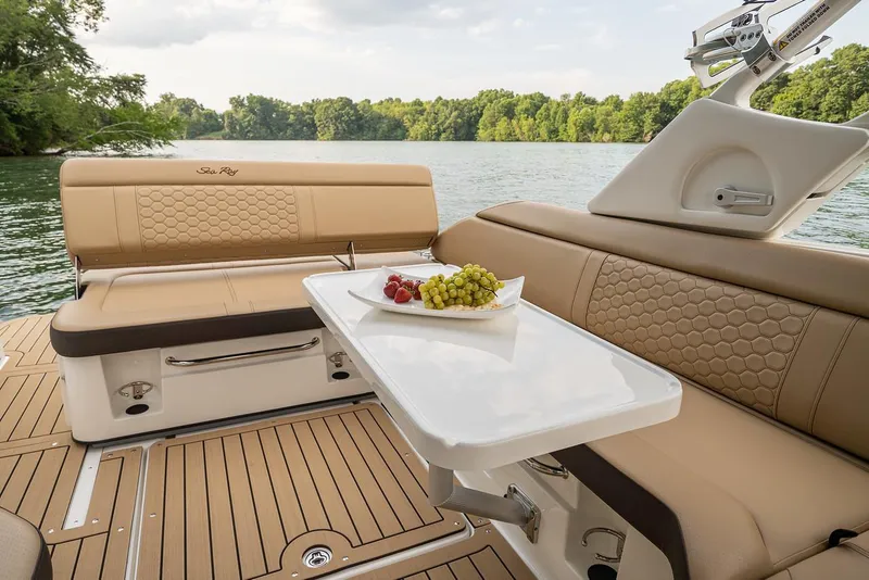 Slide: The Image of Manufacturer Provided Image: 2024 Sea Ray SDX 250 Outboard boat interior with table and seating by the water. - 2
