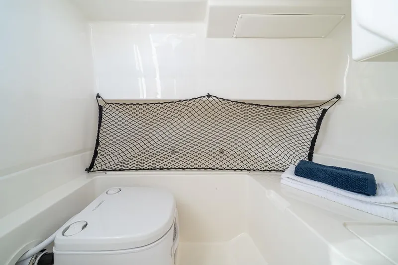 Slide: The Image of Manufacturer Provided Image: 2024 Sea Ray SDX 250 Outboard boat interior with toilet and storage net. - 20