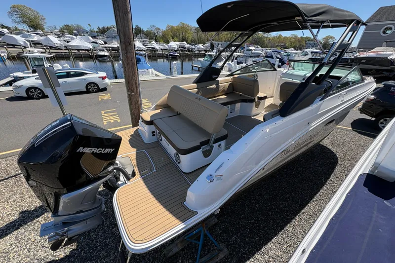 Slide: The Image of 2024 Sea Ray SDX 250 Outboard boat docked, featuring spacious seating and Mercury engine. - 6