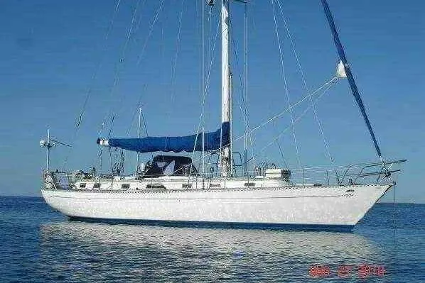 The Image of 1987 Cheoy Lee Pedrick 47 sailboat on calm blue water under clear sky. - 0