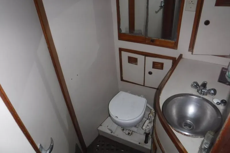 Slide: The Image of 1987 Cheoy Lee Pedrick 47 yacht bathroom with toilet, sink, and storage cabinets. - 10