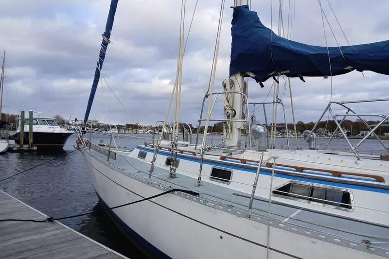 Slide: The Image of 1987 Cheoy Lee Pedrick 47 sailboat docked at a marina under cloudy skies. - 15