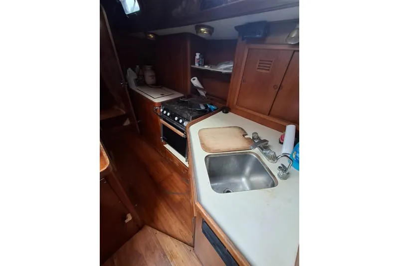 Slide: The Image of 1987 Cheoy Lee Pedrick 47 yacht kitchen with stove, sink, and wooden cabinetry. - 7
