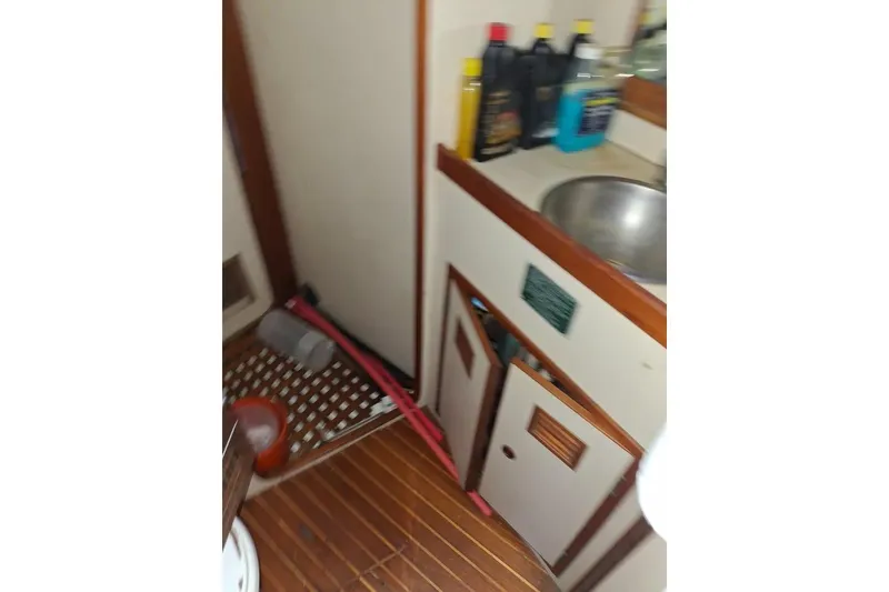 Slide: The Image of 1987 Cheoy Lee Pedrick 47 yacht interior with sink, cabinets, and cleaning supplies. - 8