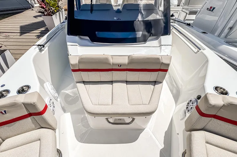 Slide: The Image of 2026 Wellcraft 28 T-Top boat interior with beige seating and red accents. - 4