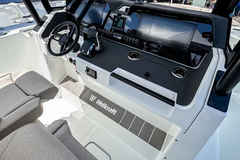 Slide: The Image of Interior view of 2026 Wellcraft 28 T-Top boat cockpit with modern controls. - 6