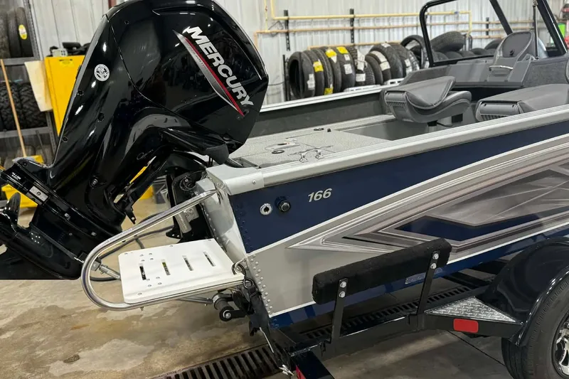 Slide: The Image of 2023 Starcraft Stealth 166 DC boat with Mercury outboard motor in a garage setting. - 3